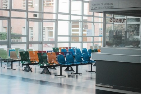 A waiting room with multi-colored chairs and a wall of windows.